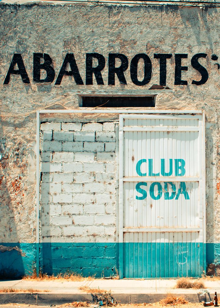 An old building with worn signage and a closed entrance in Pedro Meoqui, Mexico.