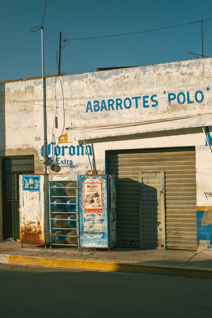 Vintage vending machine on a rustic street corner in warm afternoon light.